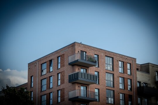 A beautiful apartment with a balcony overlooking a cloudy blue sky.
