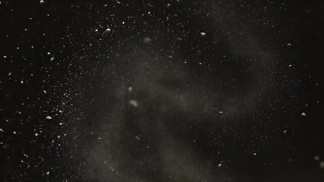 Abstract image with scattered small white particles against a dark gradient backdrop