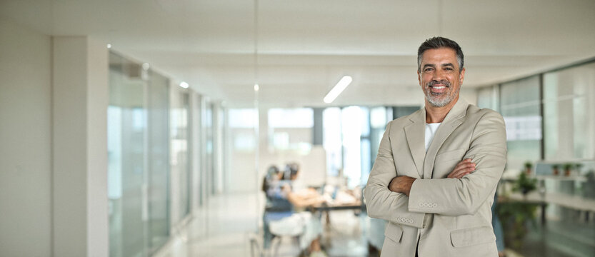 Portrait of confident happy rich middle aged business man investor, older team leader, mature professional company executive wearing suit standing arms crossed in office, chairman profile photo.