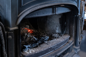 冬の暖房器具である薪ストーブの中で赤く燃える炭の熾火
