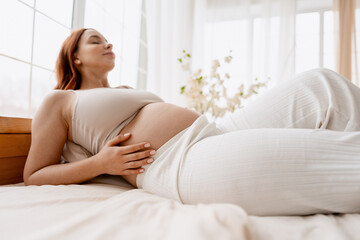 Pregnant woman relaxing in bed, embracing motherhood and wellness during pregnancy