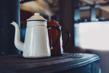 薪ストーブの天板に置かれている2つのホーローケトル,
