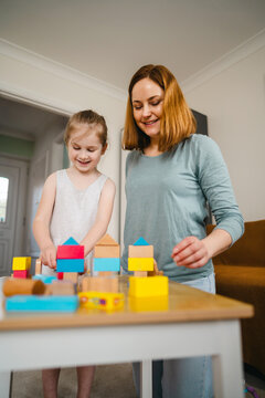 Play time, family together. Mum and child playing with wooden blocks