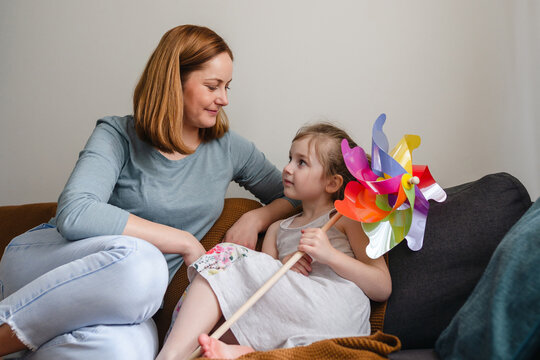 Mother and daughter having time together ob sofa at home