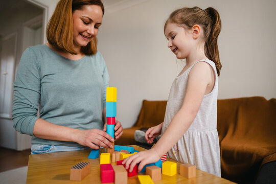 Mother and daughter playing together at home, bonding moment