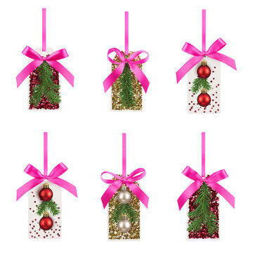 Collection of festive handmade tags with pink ribbons and christmas decorations