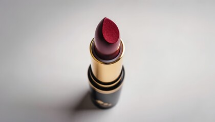 Luxurious maroon lipstick tube with gold accent on a clean white surface