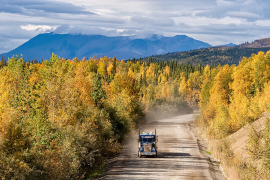 Trucker on the Dalton Highway in autumn Alaska wilderness