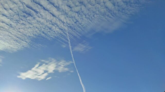 A white trail in the blue sky after an airplane