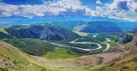 Mountain valley, aerial view, snow-capped mountain peaks and river meanders, daylight
