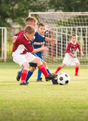 Fototapeta premium Boys kicking football on the sports field