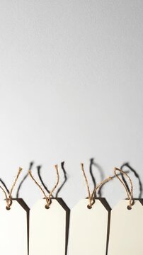 Series of four blank price tags with twine strings arranged on a clean white background, showcasing gradual movement and slight repositioning of tags