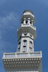 Obraz premium Tall White Minaret Of The City Mosque In Kota Kinabalu With Ornate Carvings Against A Blue Sky