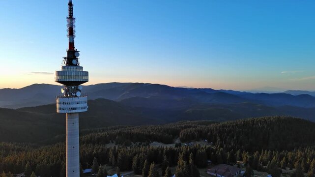 Tower Snezhana on peak of Snezhana covered with spruce forests in Rhodope mountains