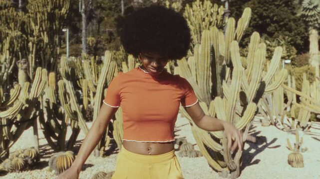 Vintage film style cuban woman dancing in a cactus garden