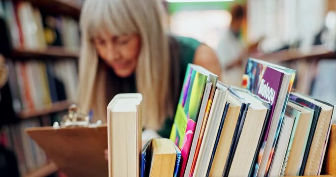 Mature, woman and work at library with pen for inspection, job with knowledge and education. Female person, office and career with paper or checking for title with fiction, research for reading