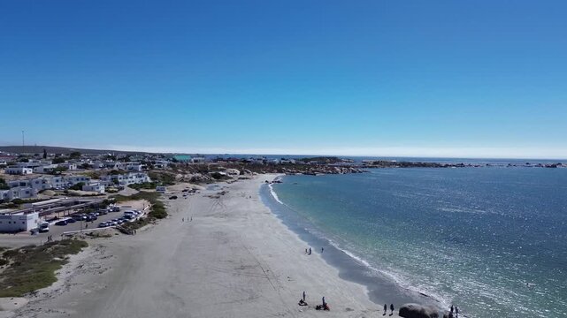 Camera panning from the rocky point over the town of Paternoster. Paternoster picturesque seaside tourist town with traditional white fishing cottages and houses. 4K Aerial Video.