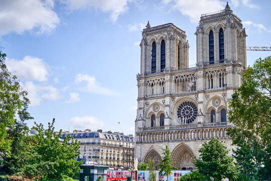 The west facade of Notre-Dame de Paris Cathedral showcasing Gothic architectural elements including twin bell towers with tall lancet windows, the large circular rose window, and intricate stone
