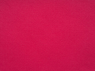 Fototapeta premium A vibrant magenta felt surface exudes a warm and tactile aesthetic