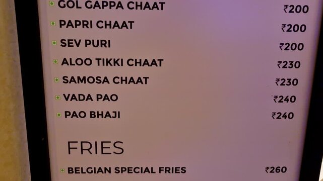 A chaat menu board listing Indian street food items and prices, including Bhel Puri, Gol Gappa Chaat, Papri Chaat, Sev Puri, Aloo Tikki Chaat, Samosa Chaat, and Vada Pao.