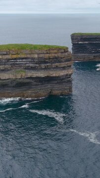 Aerial vertical view of stunning Downpatrick Head coastal landmark with iconic Dun Briste sea stack. Cliffs and waves, raw beauty of Ireland's west coast. Wild Atlantic Way Signature Discovery Point.