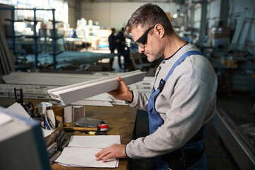 Professional production workers in coverall working with different PVC windows