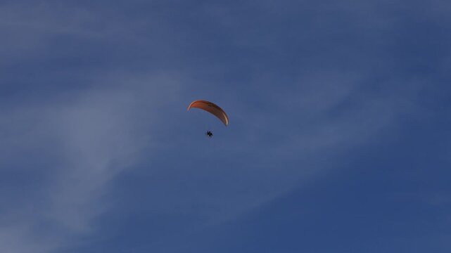 
Athlete soaring through the sky with a paramotor and parachute