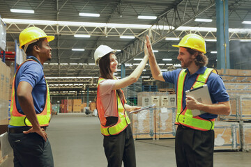 Group happy workers in the warehouse greeted each other with high-fives showing unity, encouragement cooperation and good spirits among employees in the warehouse organization. © ฺฺฺBoonterm