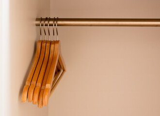 Many wooden clothes hangers on wooden rack in a white background wardrobe.