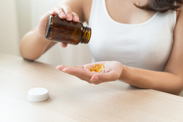Fototapeta premium person prepare fish oil pills to her hands taking daily supplement