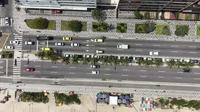 Drone top-down view of Copacabana coastal road with traffic and palm trees, Rio de Janeiro
