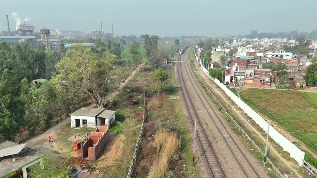 Aerial 4k shot of Vande Bharat Train Running in farm field in India