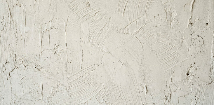 Textured wall surface with a rough, uneven finish. The background is a light color, showing subtle variations and patterns typical of plasterwork or render.