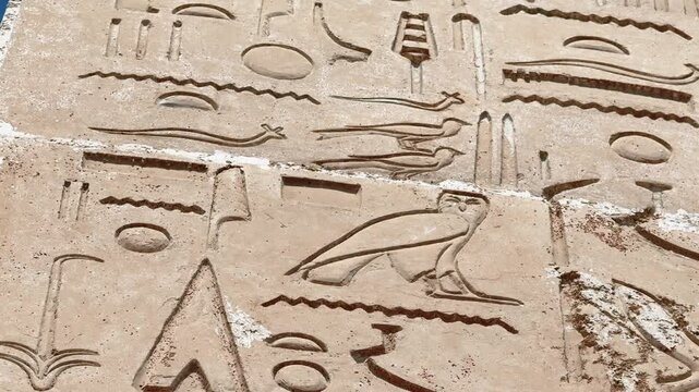 Close Up of Ancient Egyptian Hieroglyphs Carved on Replica Limestone Wall Panel