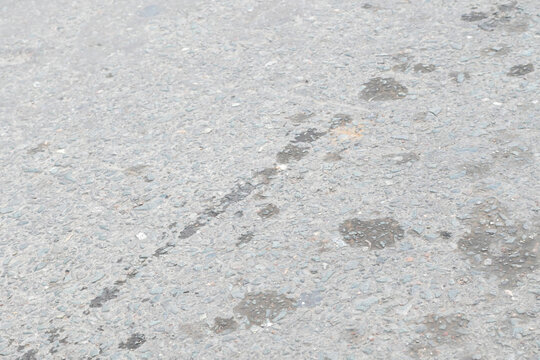 Gray asphalt road surface with texture and stains