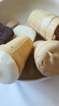 Several sweet ice cream cones with chocolate and vanilla flavors lay in a container.
