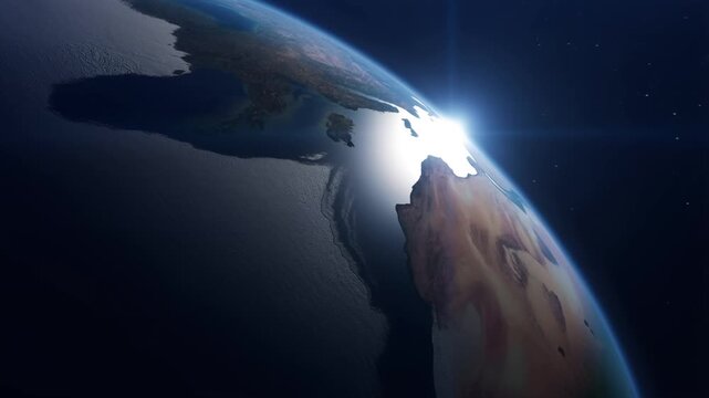 Video captures Earth's curvature from space during sunrise, with continents, oceans, and sunlight illuminating the planet, revealing space stars in the background.