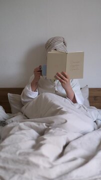 woman reading book in bed and drinking coffee, cozy morning routine, slow living aesthetic, self care and relaxation at home, ugc content, vertical