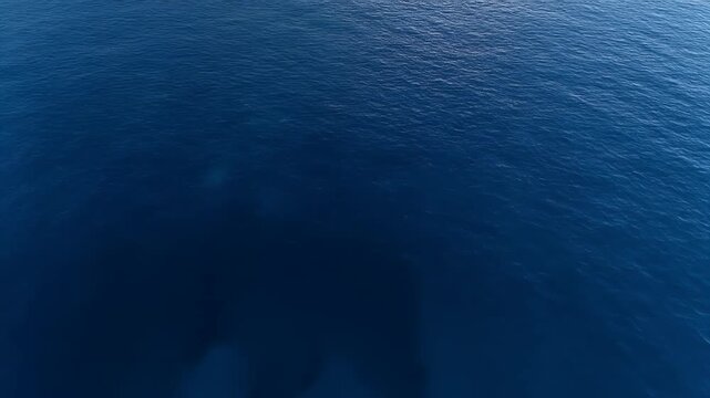 An aerial view of deep blue ocean water with subtle wave patterns.