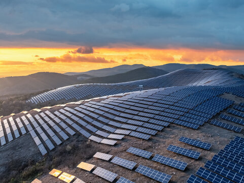 Aerial view of solar farm on mountain slopes at dusk