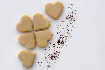Heart-shaped cookies with coffee filling and icing, with instant coffee on white background, copy space for text
