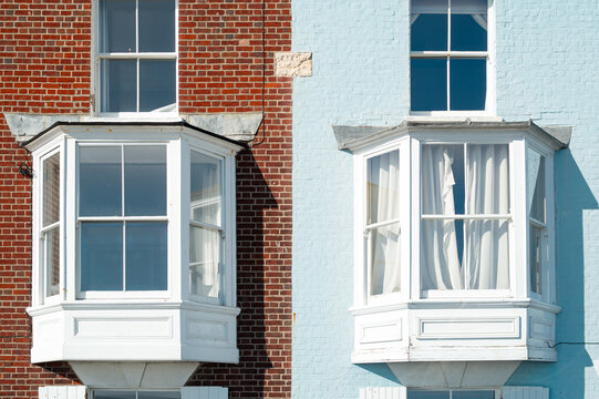 Abstract view of a pair of bay windows seen on semi detached townhouses in the UK which overlook a seaside setting on the Suffolk coast.