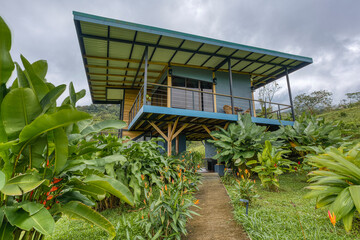 Modern stilt house in lush tropical garden setting