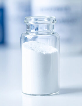 White titanium dioxide powder sample in transparent glass vial, pharmaceutical and cosmetic raw material
