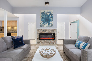 Naklejka premium Contemporary open living room with tropical decor and a fireplace in Florida a vacation rental home