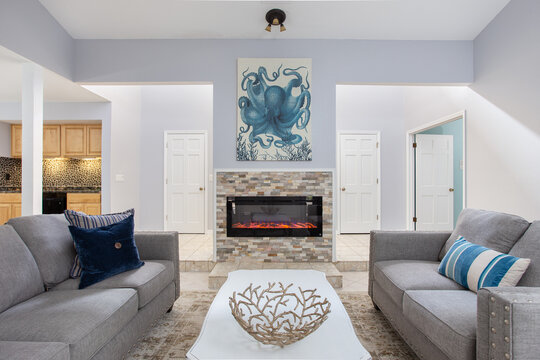 Contemporary open living room with tropical decor and a fireplace in Florida a vacation rental home