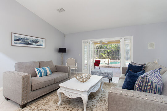 Contemporary living room that opens onto pool deck with tropical decor in Florida a vacation rental home