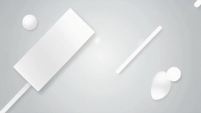 High-angle view of white geometric shapes on a gray background, including a rectangle, spheres, and a cylinder.