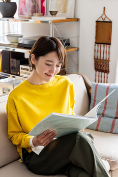 リビングで読書をする女性