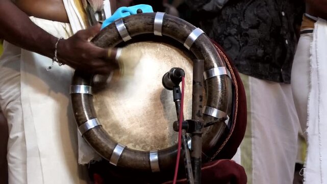 Closeup of an artist playing Thavil (Thakil), a South Indian percussion musical instrument during a temple festival celebration in Kerala, India